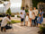 Two families wearing coordinated Hope & Henry outfits during a professional outdoor family portrait session at an elegant estate.