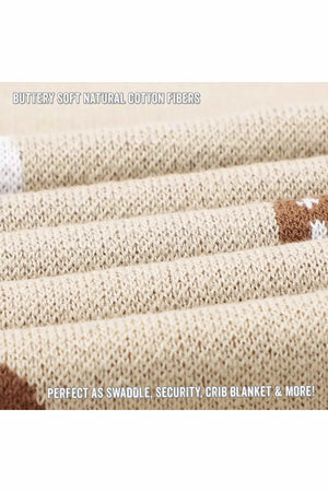 Close-up of a beige knit blanket with a textured pattern, featuring brown and white accents. Ideal for swaddling.