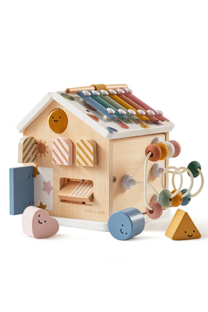 A colorful Tiny Land® wooden activity cube features a variety of shapes and textures, including a xylophone, beads, and playful designs.