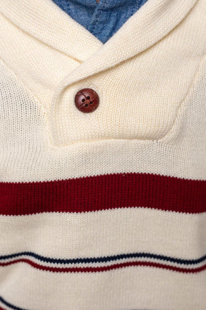 Close-up of an ivory shawl collar sweater featuring maroon and navy stripes, with a decorative button closure.