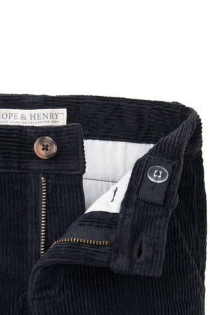 Close-up of black corduroy pants featuring a zipper, faux horn button, and organic cotton label from Hope & Henry.