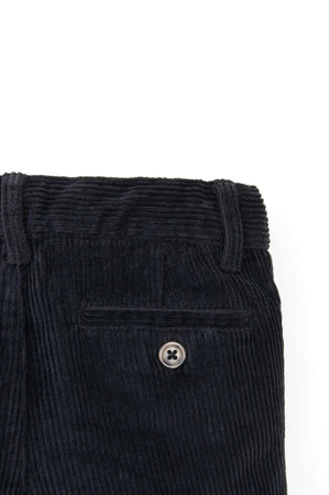 Close-up of black organic cotton stretch corduroy pants featuring a faux horn button and textured fabric.