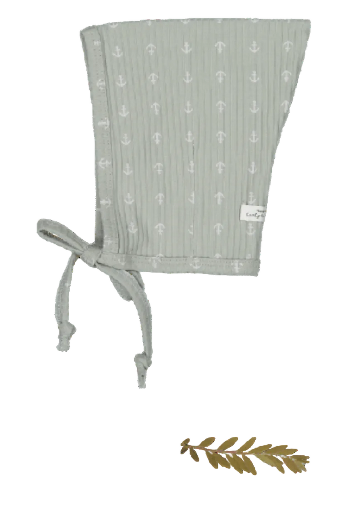 A sage green cotton bonnet with a pixie style features delicate white anchor prints. It includes adjustable ties for a secure fit, ideal for young children.
