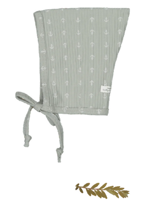 A sage green cotton bonnet with a pixie style features delicate white anchor prints. It includes adjustable ties for a secure fit, ideal for young children.
