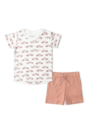 A playful organic cotton tee features a charming car print, paired with soft, terracotta shorts. This sustainable outfit is perfect for little ones adventures, offering comfort and style.