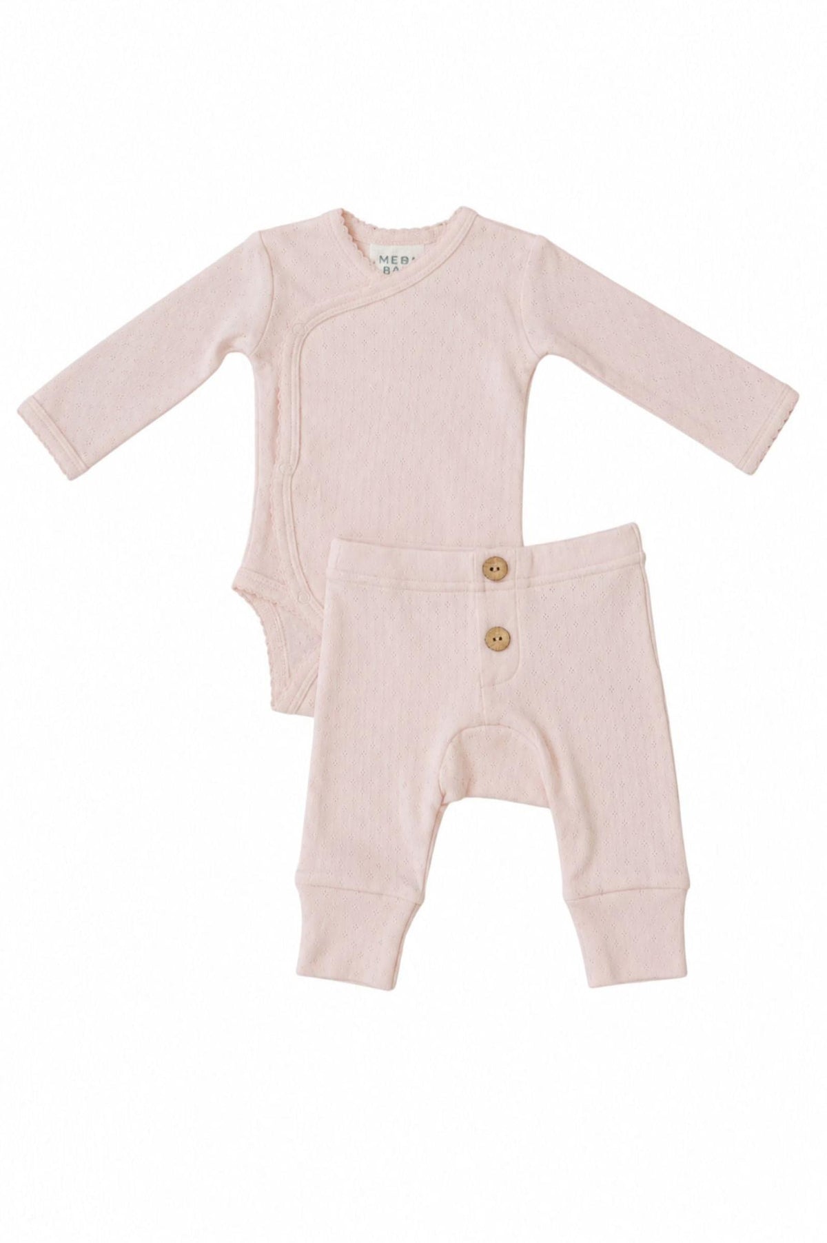 A pink pointelle layette set for baby girls, featuring a long-sleeve bodysuit with a wrap design and matching pants with decorative wooden buttons. Crafted from soft, breathable cotton for comfort.