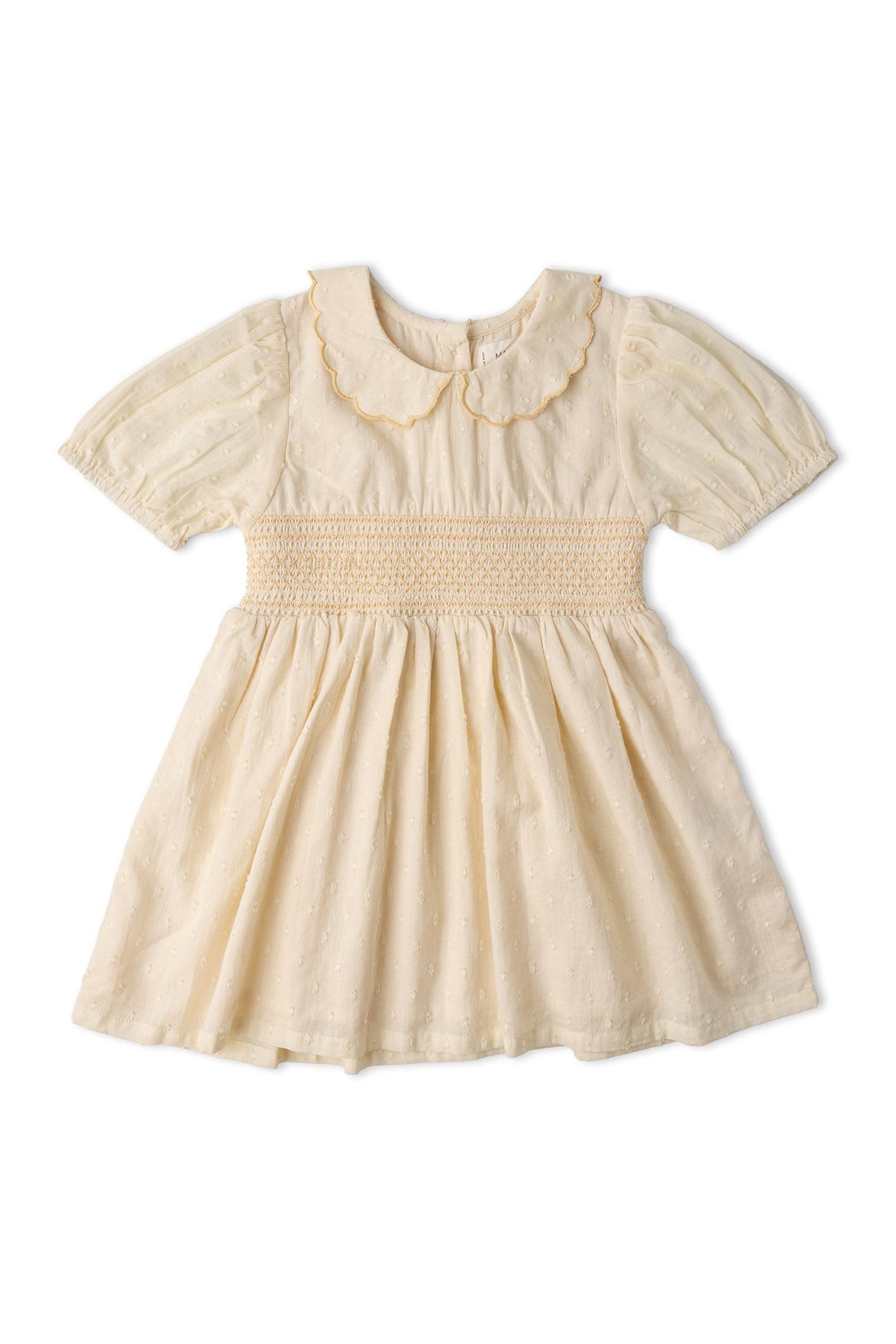 A soft butter yellow dress featuring a smocked collar and puffed sleeves. Made from organic cotton, it has a vintage-inspired design ideal for children’s playdates and special occasions.