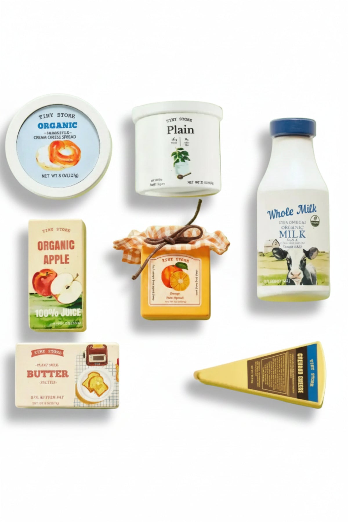 An assortment of wooden play food items on a light green background, featuring organic milk, juice, butter, and cheese, all with colorful, playful packaging designed for imaginative play.