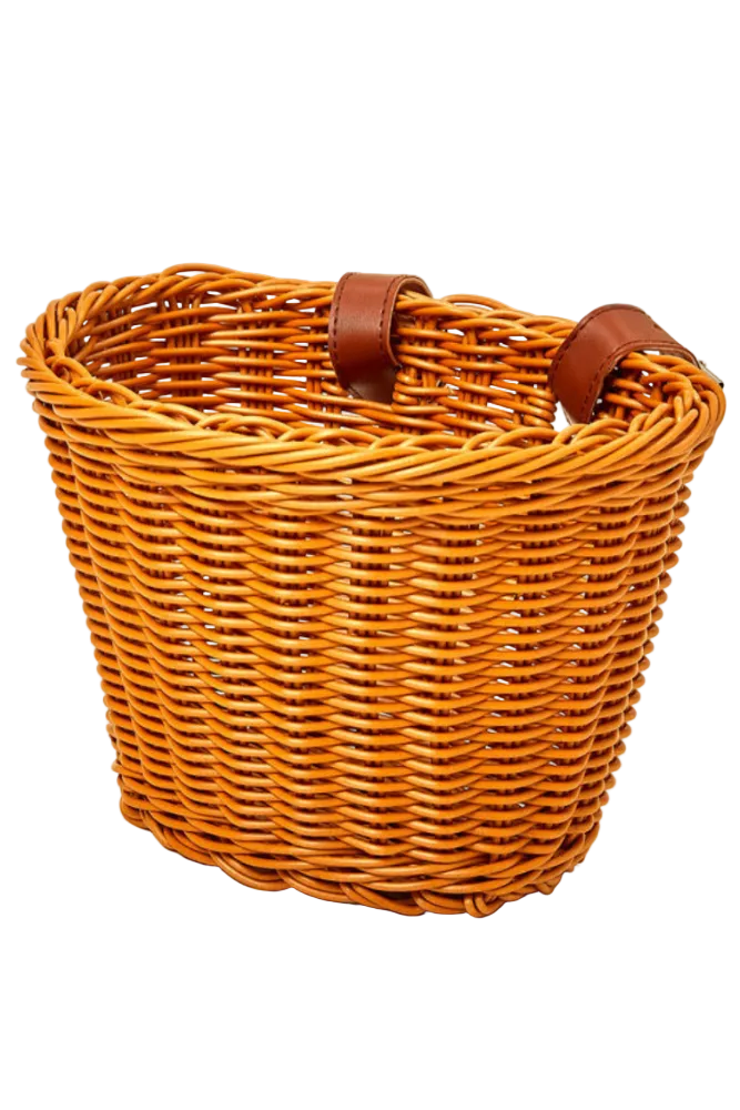 A handcrafted woven bike basket made from sustainable materials, featuring a warm, natural finish and genuine leather straps. Ideal for carrying treasures on family adventures.