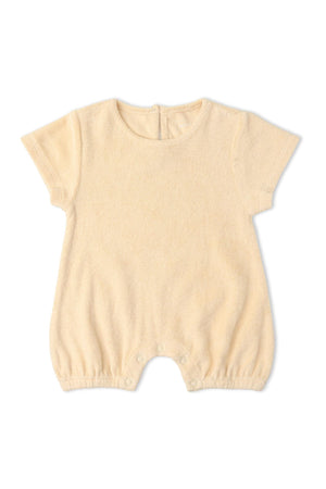 Butter yellow organic cotton short romper featuring a relaxed silhouette and soft texture, designed for comfort and play. Ideal for warm-weather adventures and made by Makemake Organics.