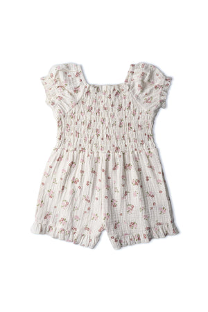 Organic cotton blush floral jumpsuit featuring soft smocking, ruffled sleeves, and a lightweight muslin fabric. Ideal for warm days, it combines comfort and style for little ones.