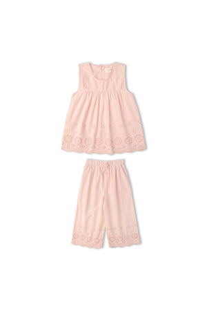 A delicate blush pink organic cotton eyelet top features intricate cutwork, paired with matching lightweight pants. This charming set is perfect for warm-weather outings and celebrations.