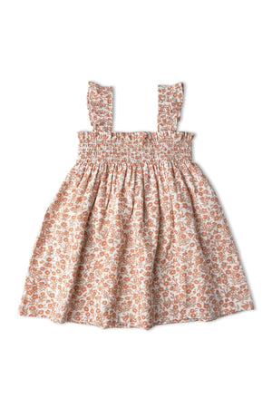 Lightweight organic cotton sundress in a sienna floral print, featuring a smocked bodice and ruffled straps. Ideal for warm days, it offers comfort and easy movement for young children.