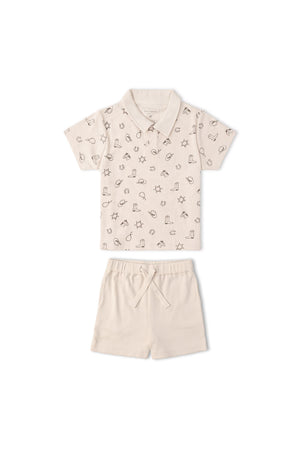A light beige organic cotton collar tee features a playful rodeo print, paired with matching shorts. This comfy set is ideal for sunny day adventures and playful activities.