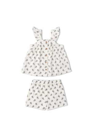 A two-piece organic cotton set features a flutter top with floral patterns and matching shorts. Perfect for summer, this lightweight outfit ensures comfort for kids during warm days.