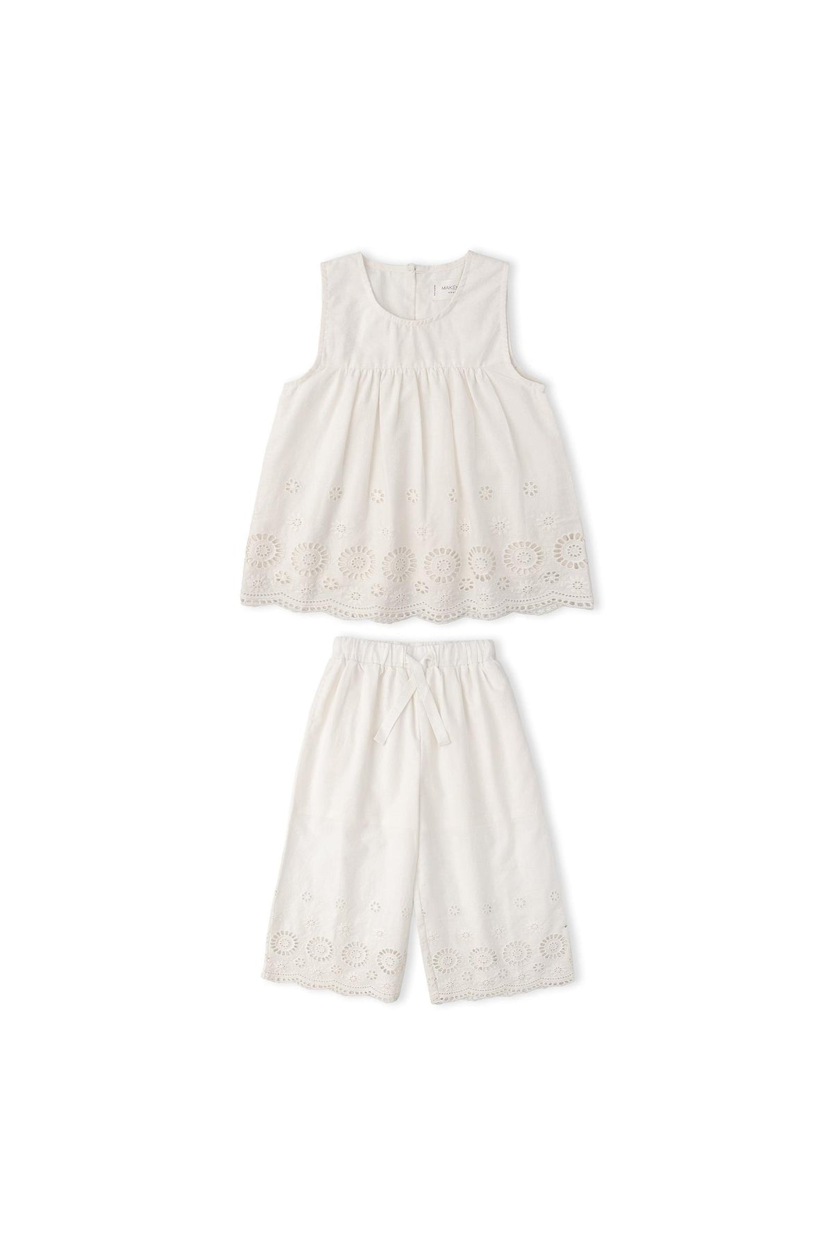 Organic Eyelet Top and Pant Set in ivory features delicate embroidered eyelet fabric. The breezy silhouette and intricate cutwork make it ideal for warm-weather outings or special occasions.