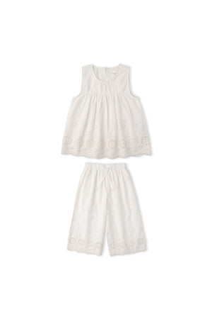 Organic Eyelet Top and Pant Set in ivory features delicate embroidered eyelet fabric. The breezy silhouette and intricate cutwork make it ideal for warm-weather outings or special occasions.
