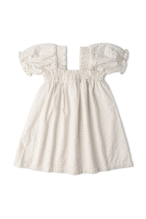 An ivory eyelet dress featuring bubble sleeves and delicate embroidery. Made from organic cotton, this dress offers a soft, breathable fit, perfect for warm-weather wear.
