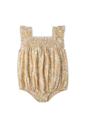 Organic yellow bubble romper featuring ruffle sleeves and a floral pattern, made from soft, breathable fabric. Ideal for playtime, this romper combines comfort with whimsical style for little ones.