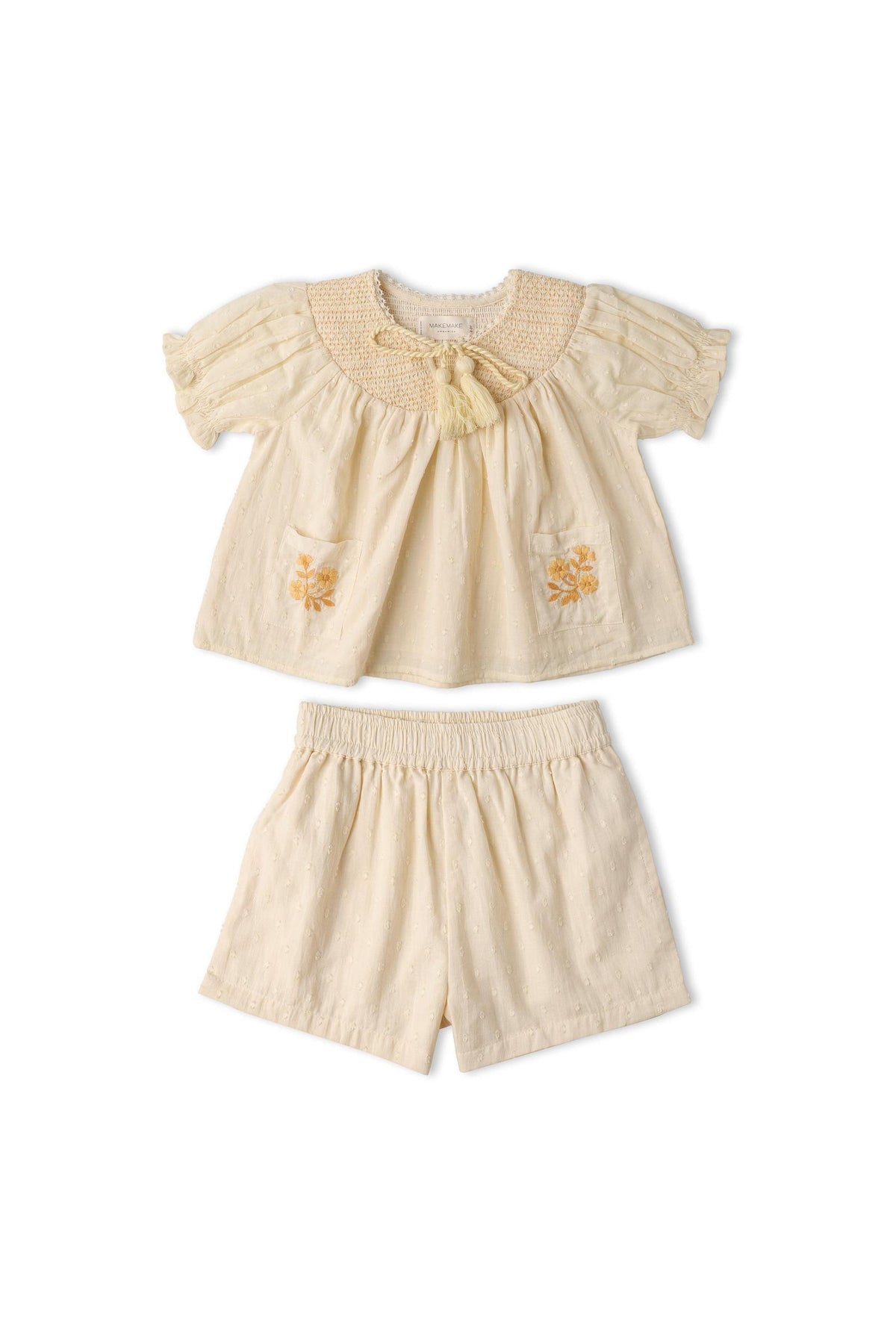 Organic cotton smocked top and shorts set in soft butter yellow, featuring delicate embroidery on the pockets. Ideal for sunny outings, offering a breezy, comfortable fit for children.