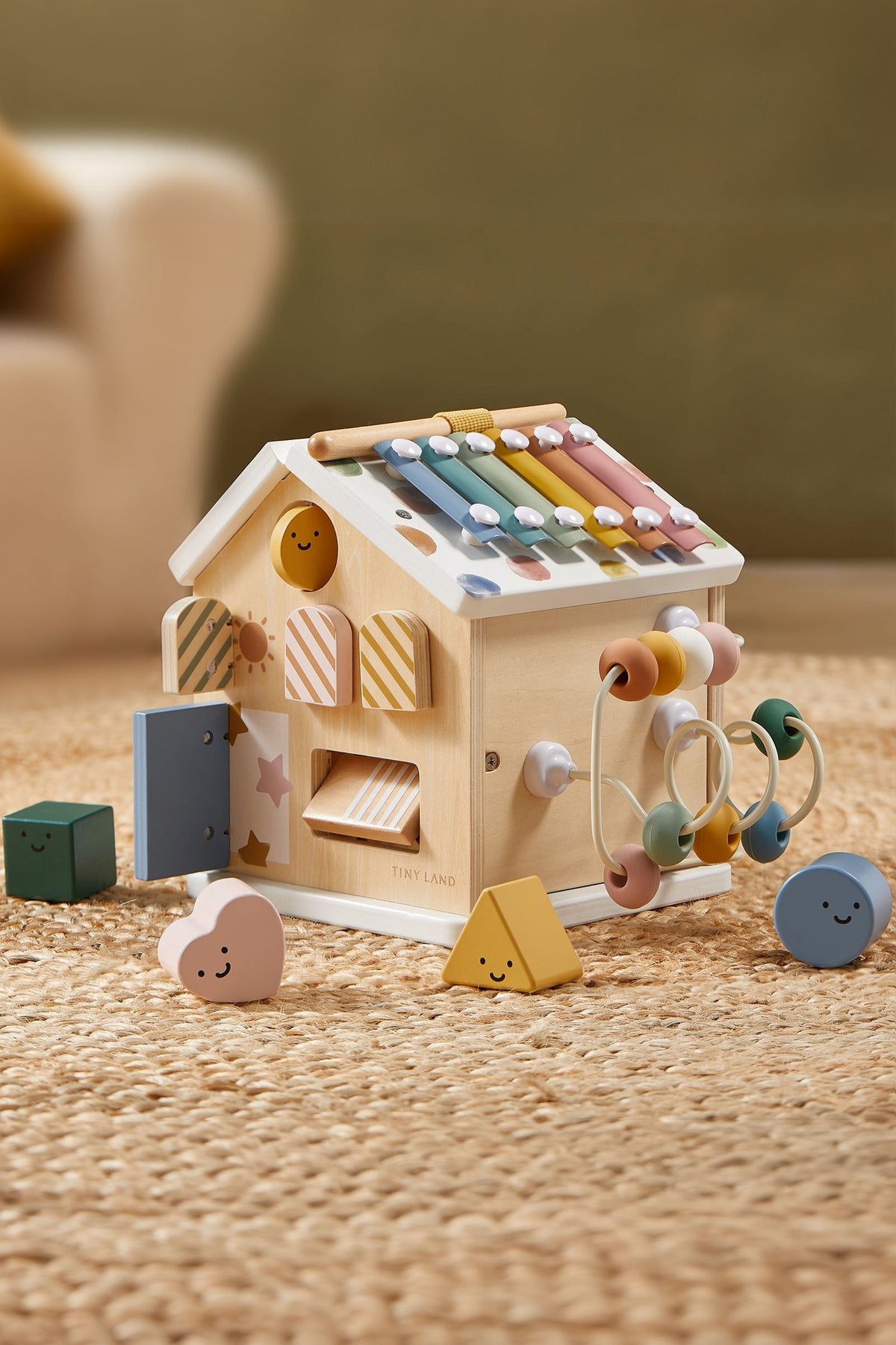Montessori-inspired Tiny Land® wooden activity cube in pastel colors, featuring various shapes and beads for interactive play. Ideal for toddlers.