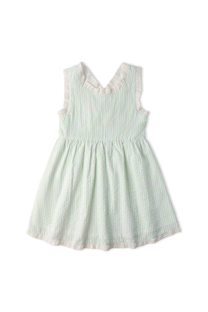 Light green seersucker dress with white stripes and a criss-cross back design. The gently gathered skirt creates a breezy, charming look, perfect for warm weather and playful twirls.