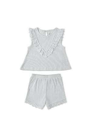 Light gray organic cotton ruffle top with a scalloped neckline paired with matching shorts featuring delicate lace trim. This charming set is perfect for young children’s warm-weather outfits.