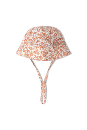 A floral-patterned bucket sun hat in soft organic cotton, featuring a wide brim and adjustable chin strap. Ideal for outdoor activities, it offers sun protection and comfort for children.