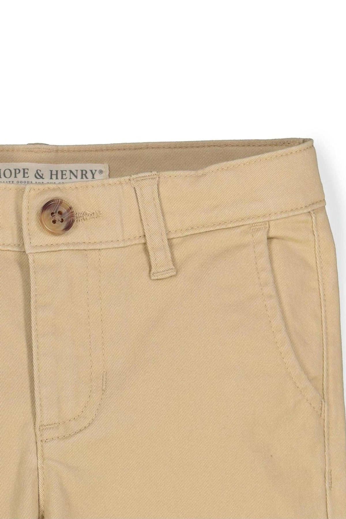 Close-up of khaki skinny chinos by Hope & Henry, featuring a faux horn button and organic cotton material.