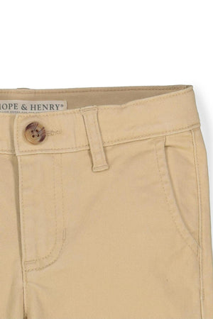 Close-up of khaki skinny chinos by Hope & Henry, featuring a faux horn button and organic cotton material.
