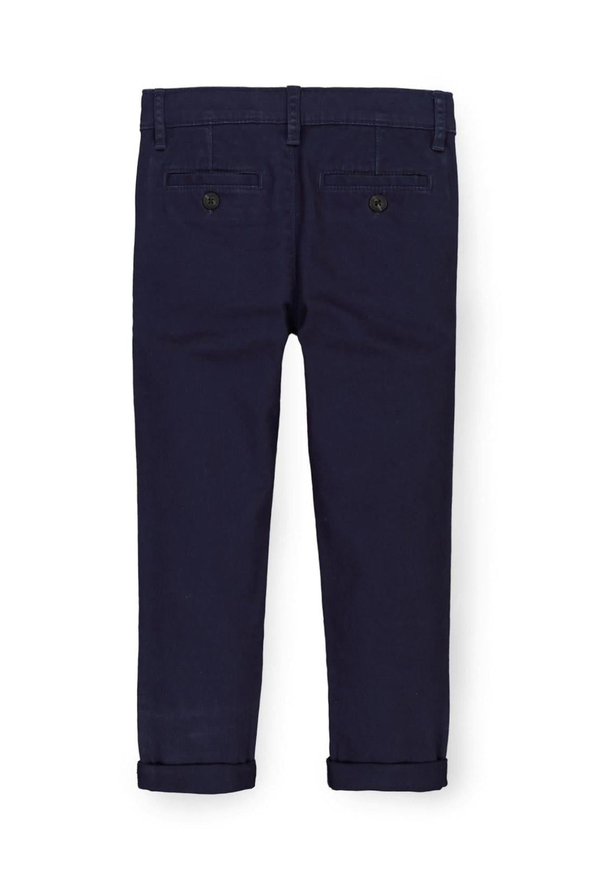 Back view of navy blue organic cotton skinny chino pants, featuring rolled cuffs and two back pockets with button closures.