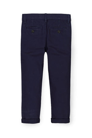 Back view of navy blue organic cotton skinny chino pants, featuring rolled cuffs and two back pockets with button closures.