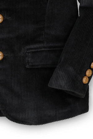 Close-up of a black corduroy blazer for boys, featuring faux suede elbow patches and brown button details. This stylish piece is made from organic cotton, emphasizing sustainable fashion.
