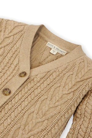 Close-up of a camel-colored chunky cable cardigan by Hope & Henry, featuring intricate knit patterns and a faux horn button.