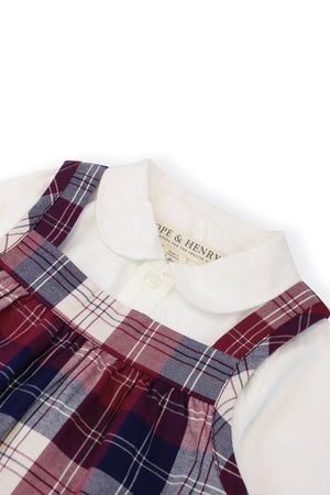 Close-up view of a Hope & Henry organic cotton bodysuit featuring a white Peter Pan collar, paired with a berry tartan plaid jumper, highlighting the vibrant colors and classic design.