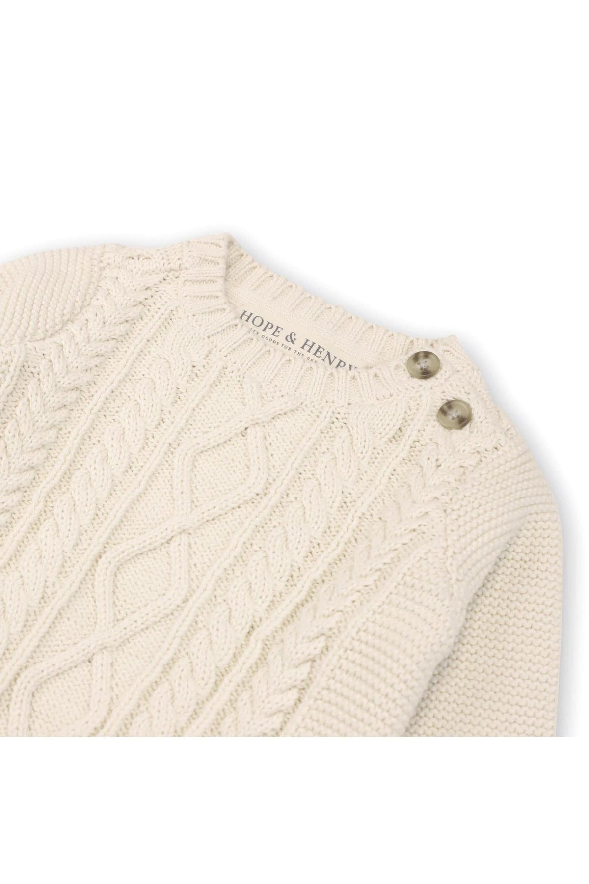 An ivory cable knit pullover from Hope & Henry features faux horn shoulder buttons, made from organic cotton, ideal for babies aged 0-24 months. Perfect for stylish, comfortable dressing.