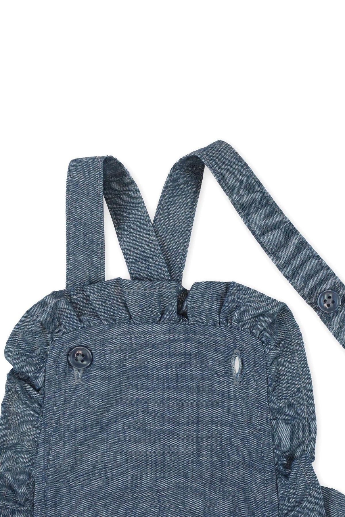 Close-up of a blue chambray ruffle sunsuit with adjustable straps and button detail, made from organic cotton for baby girls.