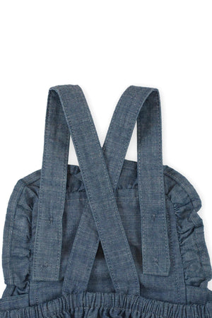 Close-up of blue chambray straps with ruffle detailing, showcasing soft organic cotton material for a baby girls sunsuit.