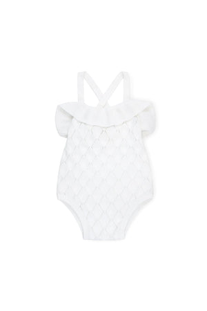 White organic cotton ruffle sweater romper featuring a pointelle knit design and cross-back straps for easy dressing.