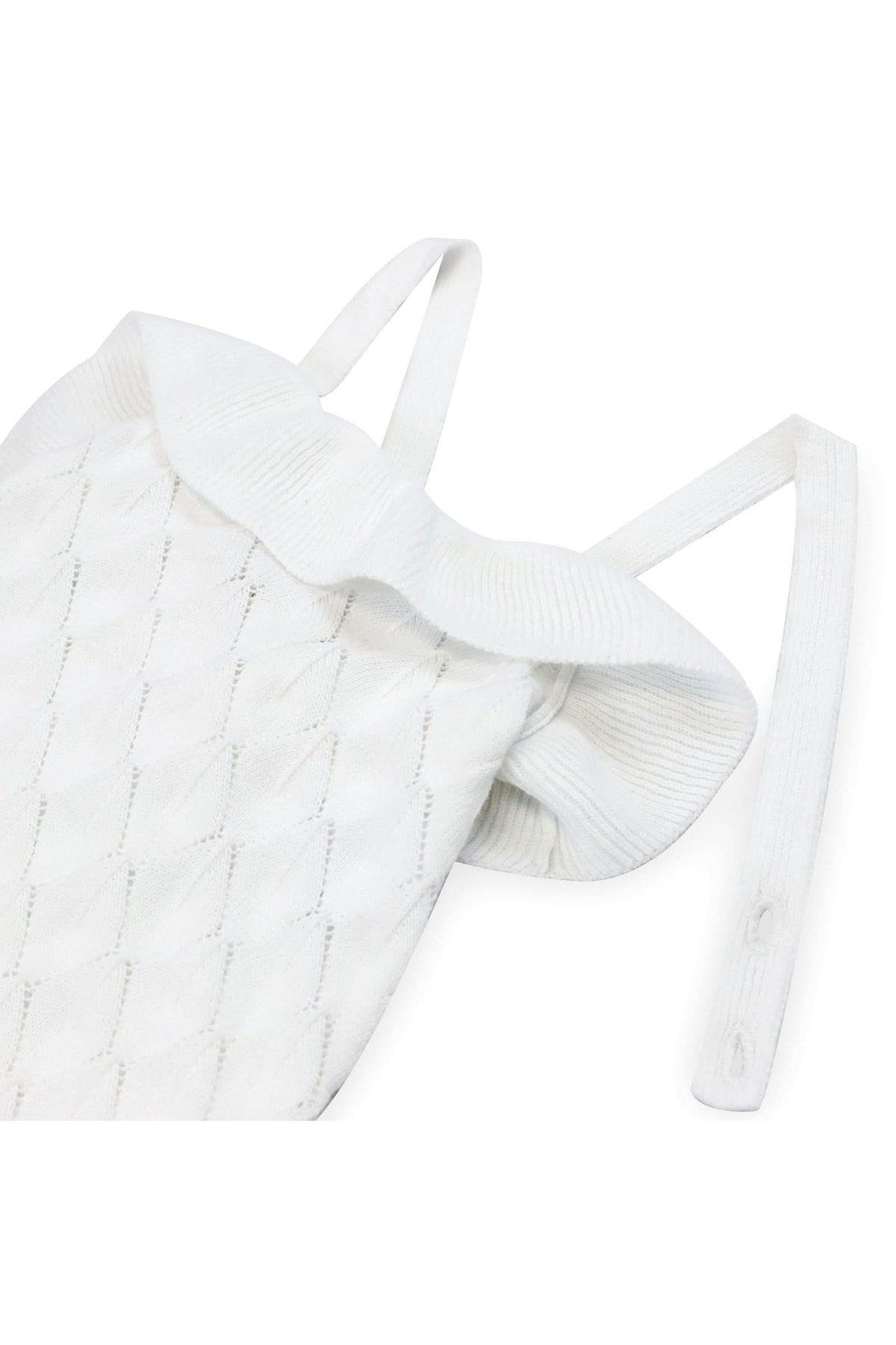 White organic cotton sweater romper featuring ruffle detailing and cross-back straps, ideal for baby girls. Soft and stylish design.