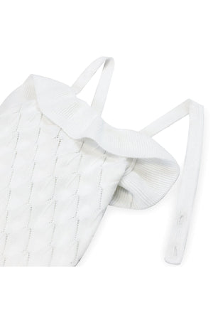 White organic cotton sweater romper featuring ruffle detailing and cross-back straps, ideal for baby girls. Soft and stylish design.