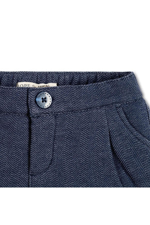 Close-up of navy blue dress shorts featuring a herringbone pattern, elastic waistband, and decorative button from Hope & Henry.