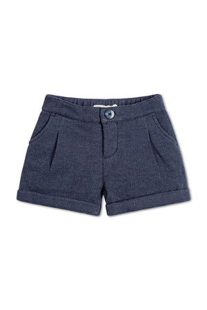 Navy blue dress shorts featuring a herringbone pattern, faux zip opening, and cuffed hem, made from organic cotton blend.