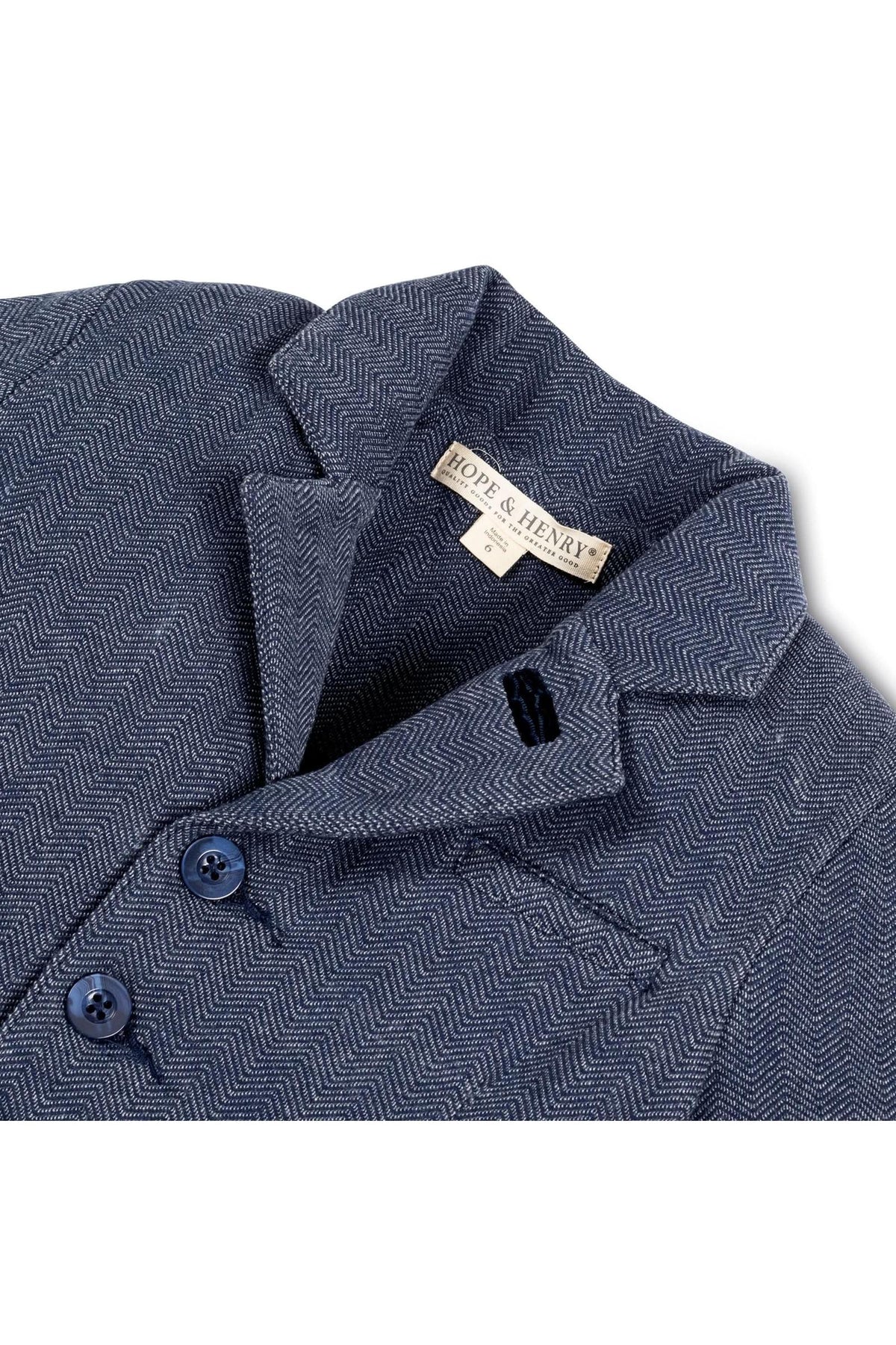 Close-up of a navy blue herringbone-patterned blazer by Hope & Henry, featuring faux leather buttons and a stylish collar.