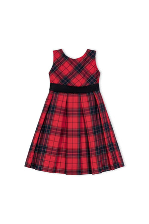 A red holiday plaid sleeveless dress features a fitted bodice, pleated skirt, and a black waistband, ideal for festive occasions.