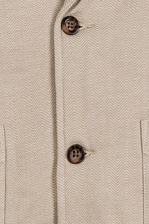 Close-up of a taupe cotton fleece blazer featuring a herringbone pattern, faux horn buttons, and two front patch pockets, highlighting its stylish and comfortable fabric suitable for various occasions.
