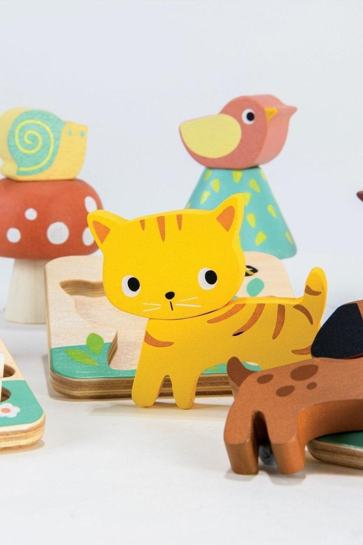 Colorful wooden animal toys, including a yellow cat, on a white background. Eco-friendly design for toddlers playtime.