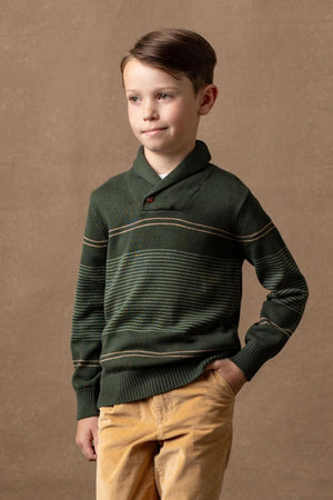A young boy is wearing a pine and sage striped shawl collar sweater made from soft organic cotton, featuring a button closure and set against a neutral brown backdrop.