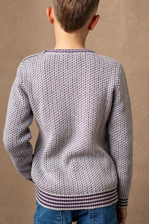 A boy wears a gray and plum intarsia sweater with ribbed trim, showcasing a textured pattern against a neutral background.