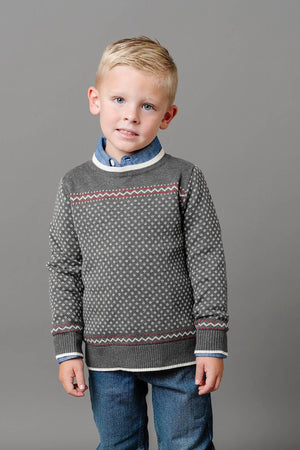 A young boy is wearing a charcoal crew neck sweater with an ivory birdseye pattern, paired with a blue collared.